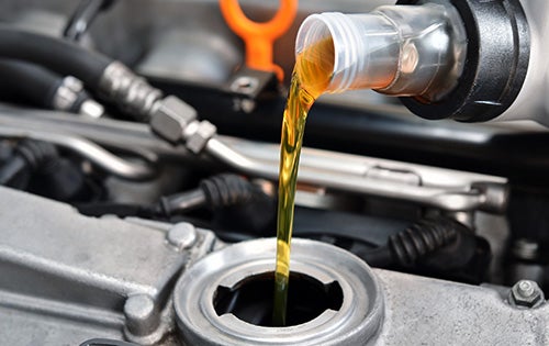 Engine oil being poured into a car engine